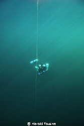 Technical diver at deco stop in crystal clear water by Harald Fauske 